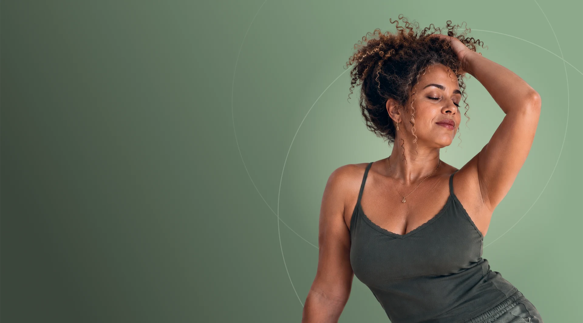 Woman with curly hair, eyes closed, one hand raised to her head