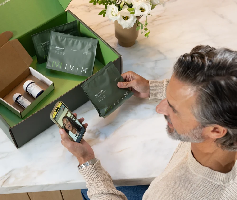 Man opening his Ivím membership kit during a video visit with his provider